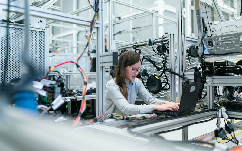 Engineer tuning a robotic system from a laptop in a laboratory