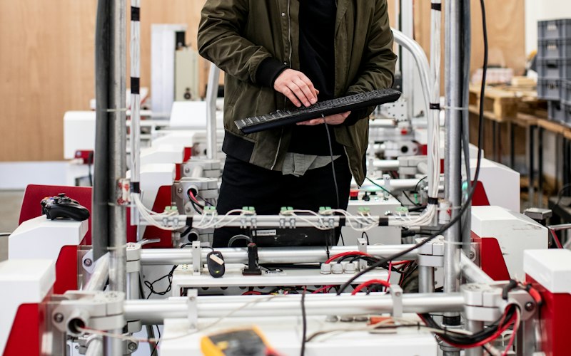 Engineer assembling and testing a robotic system frame in a workshop