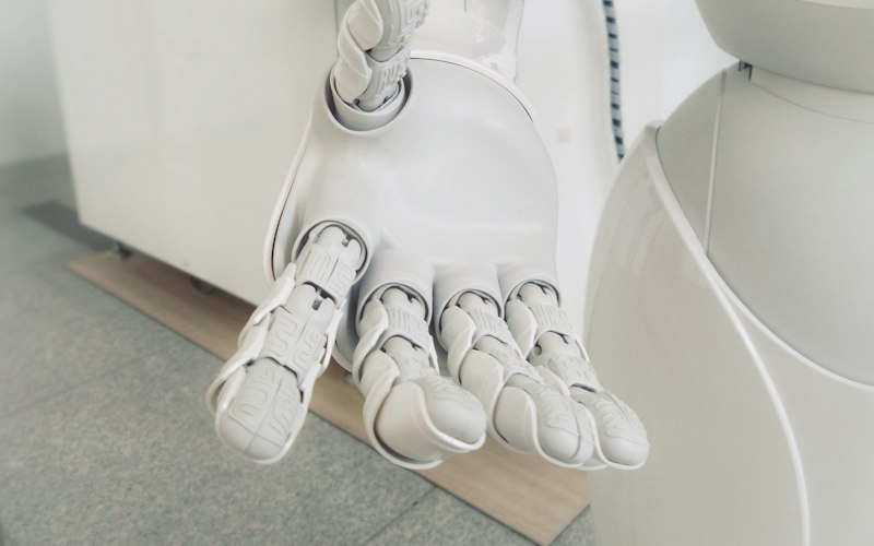 Articulated robotic hand resting on a workbench