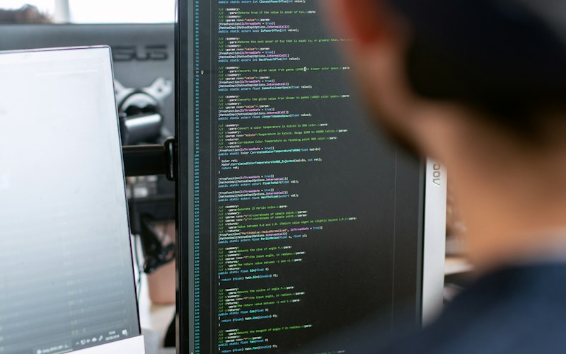 Engineer working at a multi-screen robotics software workstation