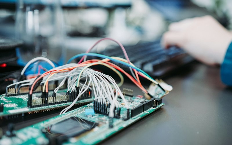 Breadboard wired to sensors and a microcontroller on an engineering bench